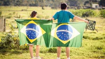 Pessoas segurando a bandeira do Brasil - Pixabay