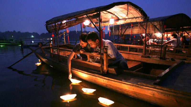 Um casal acende velas no lago Houhai para fazer desejos no Festival Qixi em 11 de agosto de 2005 em Pequim, China. - Getty Images
