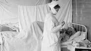Enfermeira cuidando de paciente com gripe espanhola - Wikimedia Commons