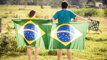 Pessoas segurando a bandeira do Brasil - Pixabay