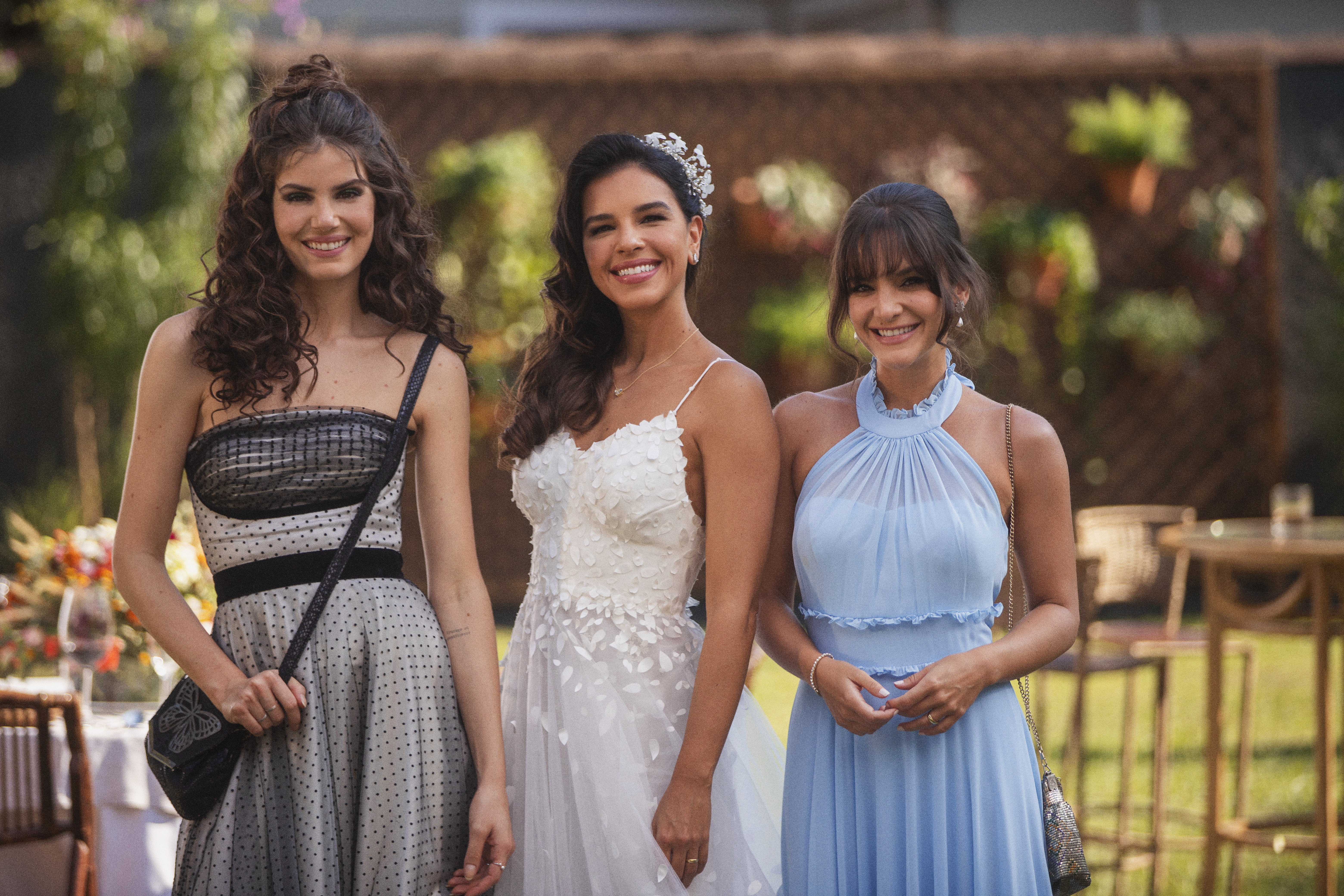Três mulheres posam para foto em uma festa de casamento